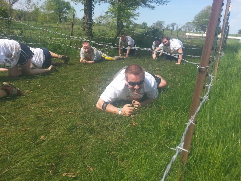 Kris Ninnis crawling under barbed wire.